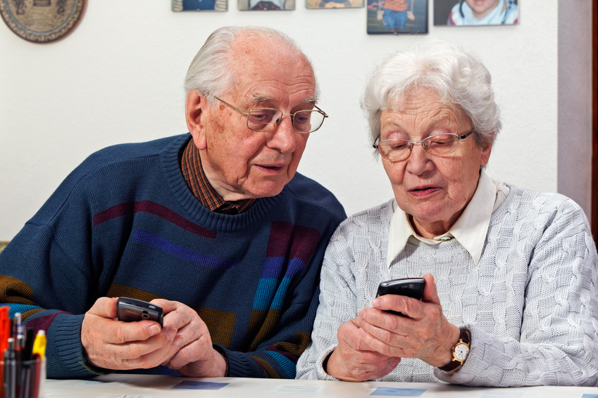 Seniorin und Senior mit Mobiltelefonen